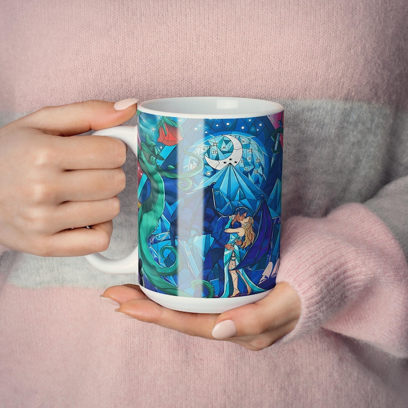 a woman holding a coffee mug with a picture of a mermaid on it
