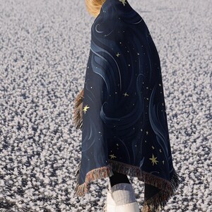 a woman wrapped in a blanket standing in the snow