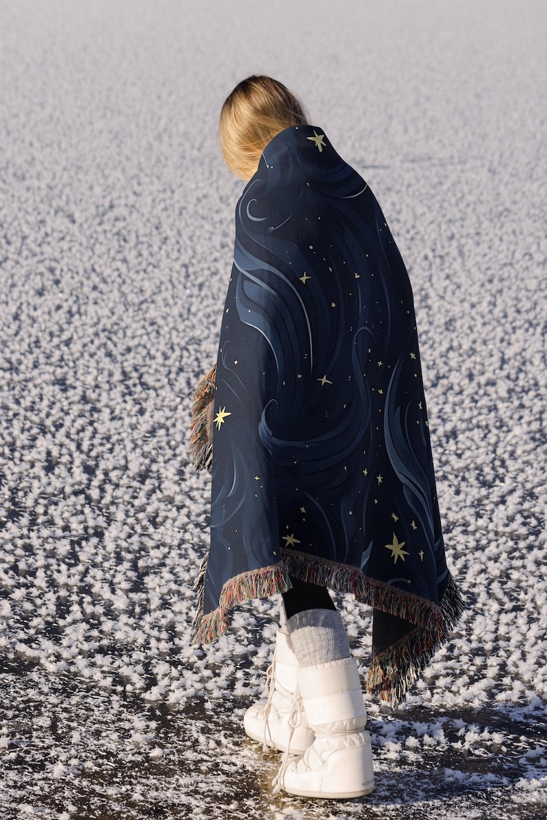 a woman wrapped in a blanket standing in the snow