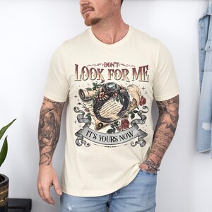 a man with a tattooed arm standing in front of a wall