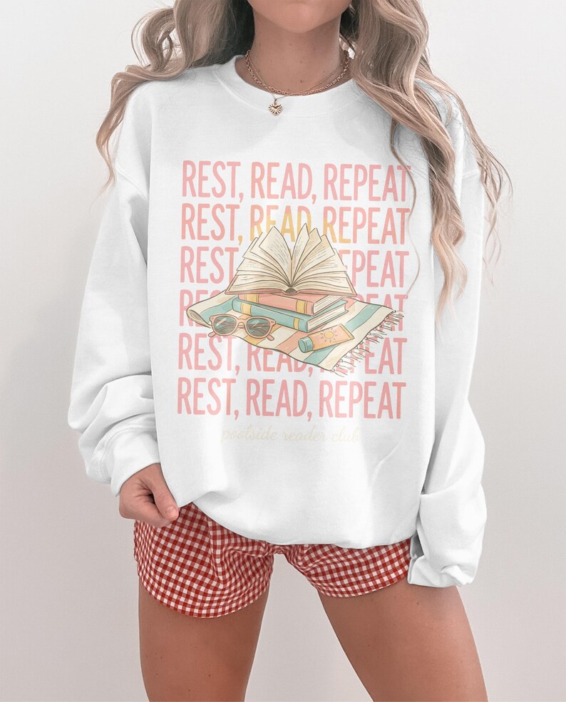 Sweatshirt with "REST, READ, REPEAT" and a stack of books.