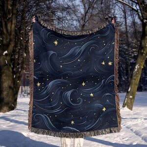 a person standing in the snow holding a blanket