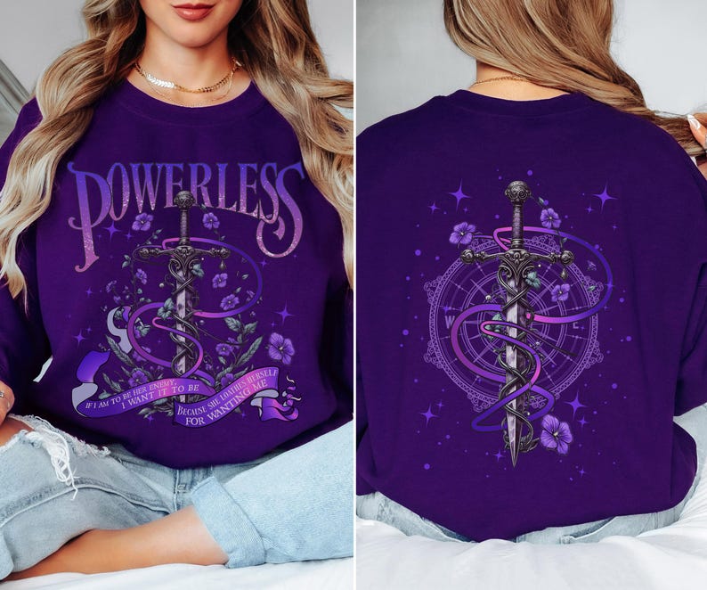 a woman sitting on a bed wearing a purple sweatshirt