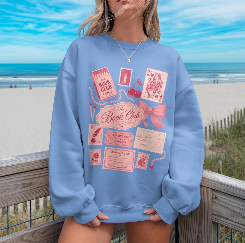 Light blue sweatshirt with "The Book Club" text and vintage library-themed graphics.