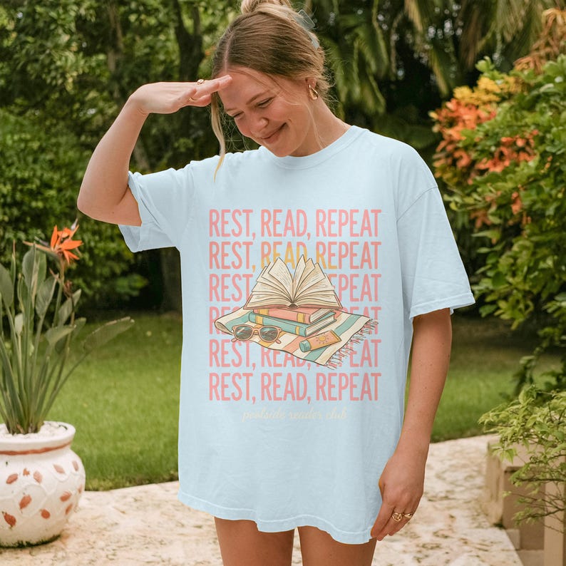 Woman in white t-shirt with "REST, READ, REPEAT" text and books graphic.