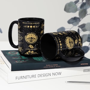 two coffee mugs sitting on top of a book