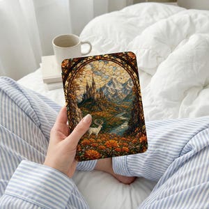 Stained glass art of a castle and deer set in a floral, mountainous landscape.