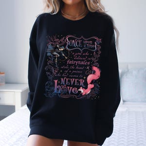 a woman wearing a black sweatshirt with a quote on it