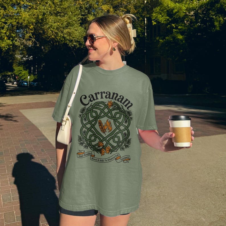 Woman wearing a green t-shirt with a Celtic knot design and "Carranam" text.