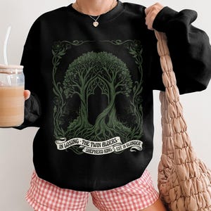 Black crewneck sweatshirt with green tree design and text.