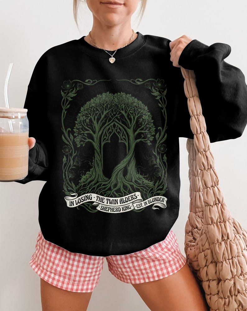 Black crewneck sweatshirt with green tree design and text.