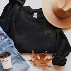 a hat, sweater, jeans, and a cup of coffee on a table