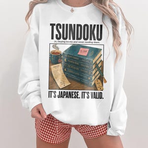Sweatshirt with "TSUNDOKU" text, books, and receipt.