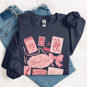 Navy sweatshirt with book club themed illustrations and text.