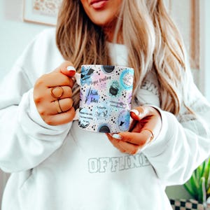 a woman in a white sweatshirt holding a cell phone