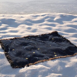a blanket laying on top of a snow covered ground