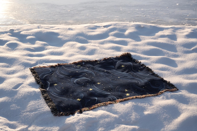 a blanket laying on top of a snow covered ground