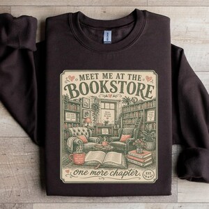 Dark brown sweatshirt with "Meet Me at the Bookstore" graphic.