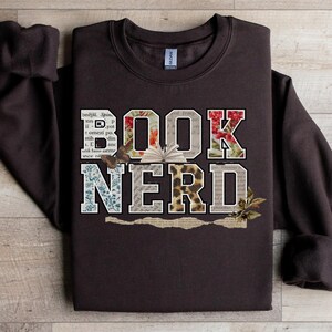 Brown sweatshirt with "BOOK NERD" text in floral and animal print.