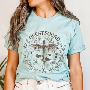 a woman wearing a t - shirt that says quest squad