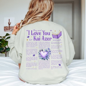 a woman sitting on top of a bed wearing a sweatshirt