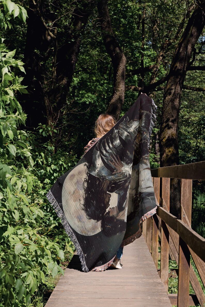 a woman walking across a bridge holding a scarf