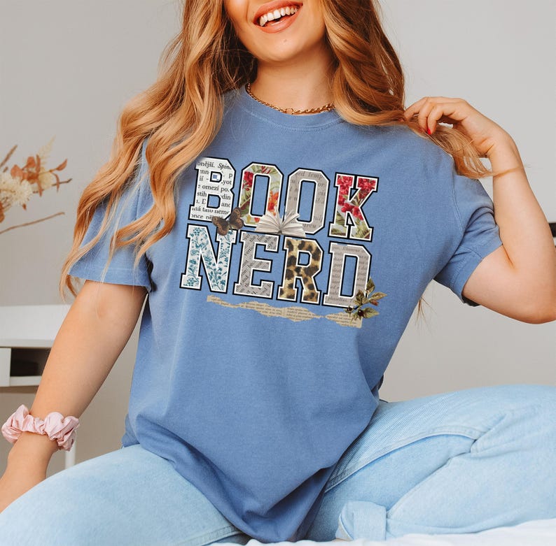 Blue t-shirt with "BOOK NERD" text in distressed, collage style.