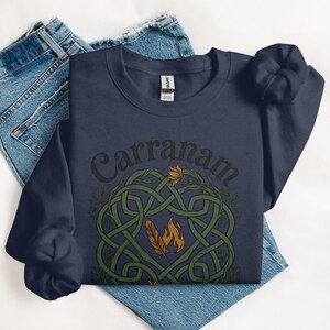 Navy sweatshirt with Celtic knot design featuring feathers and flames.