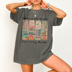 Gray t-shirt with books, flowers, and butterflies; text reads "there's no such thing as too many books."