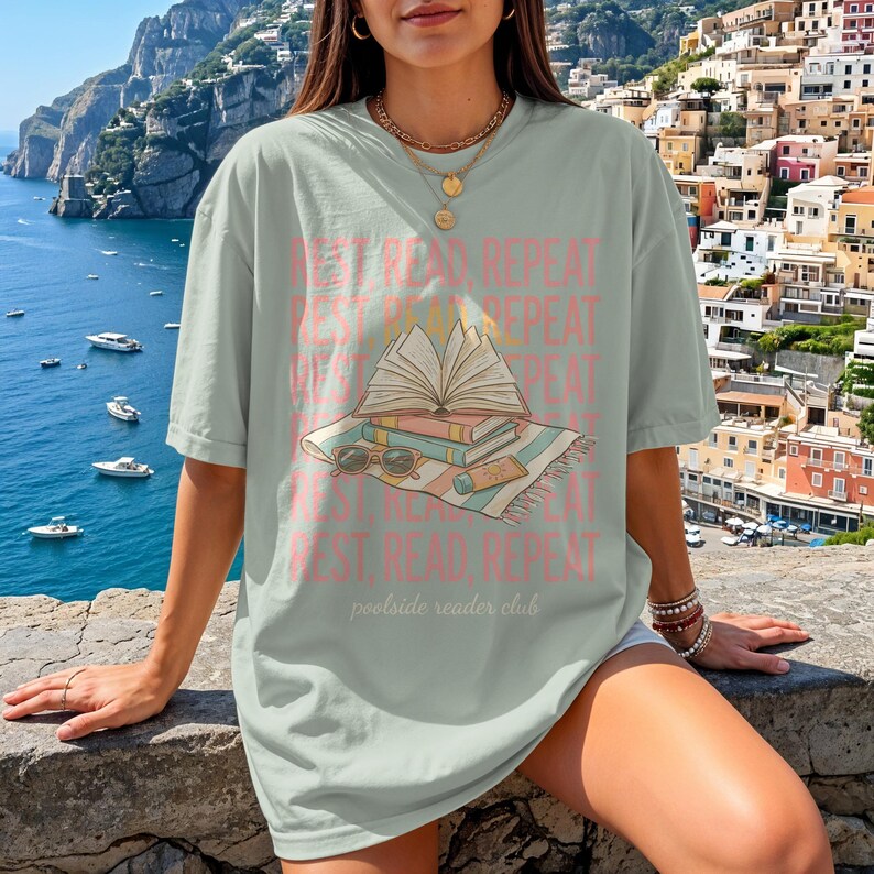 T-shirt with stacked books and sunglasses, "rest. read. repeat." text.