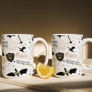 two coffee mugs sitting on a table with a slice of lemon