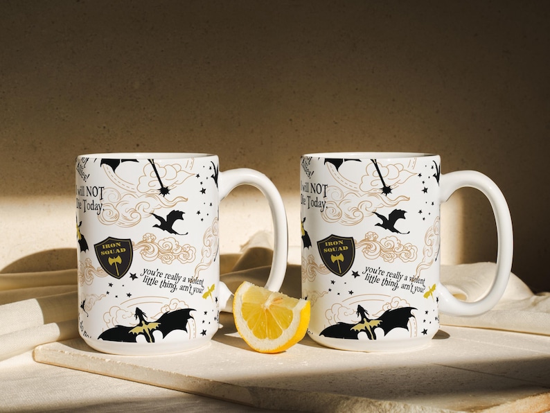 two coffee mugs sitting on a table with a slice of lemon