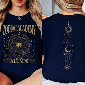a woman sitting on a bed wearing a zodiac t - shirt