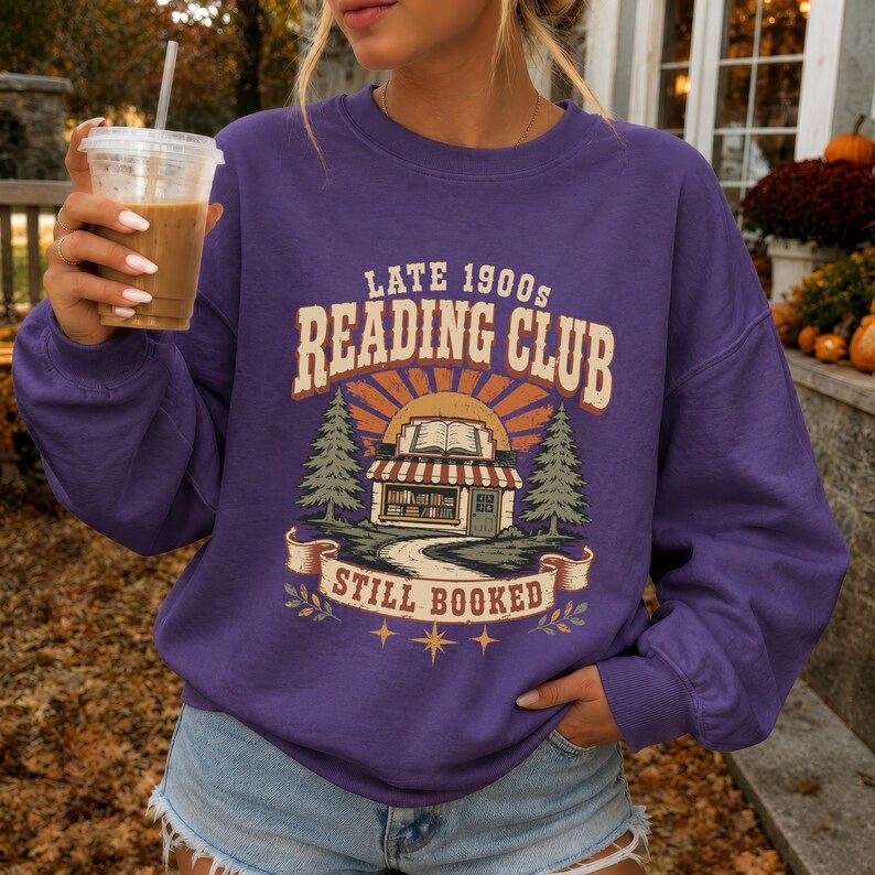 Purple sweatshirt with "Late 1900s Reading Club Still Booked" graphic.