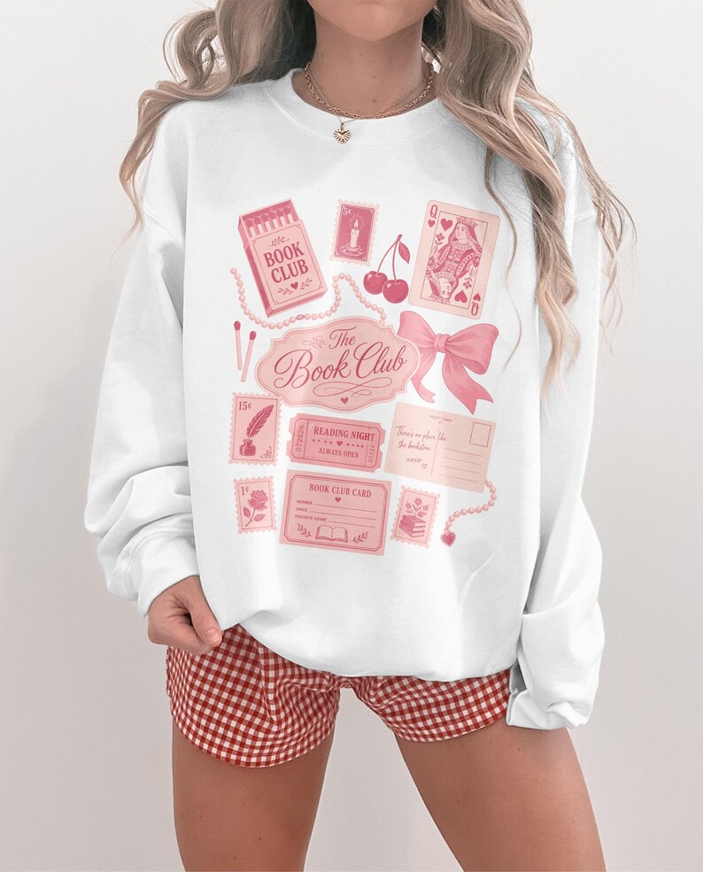 Pink sweatshirt with "The Book Club" graphics including cherries and playing cards.