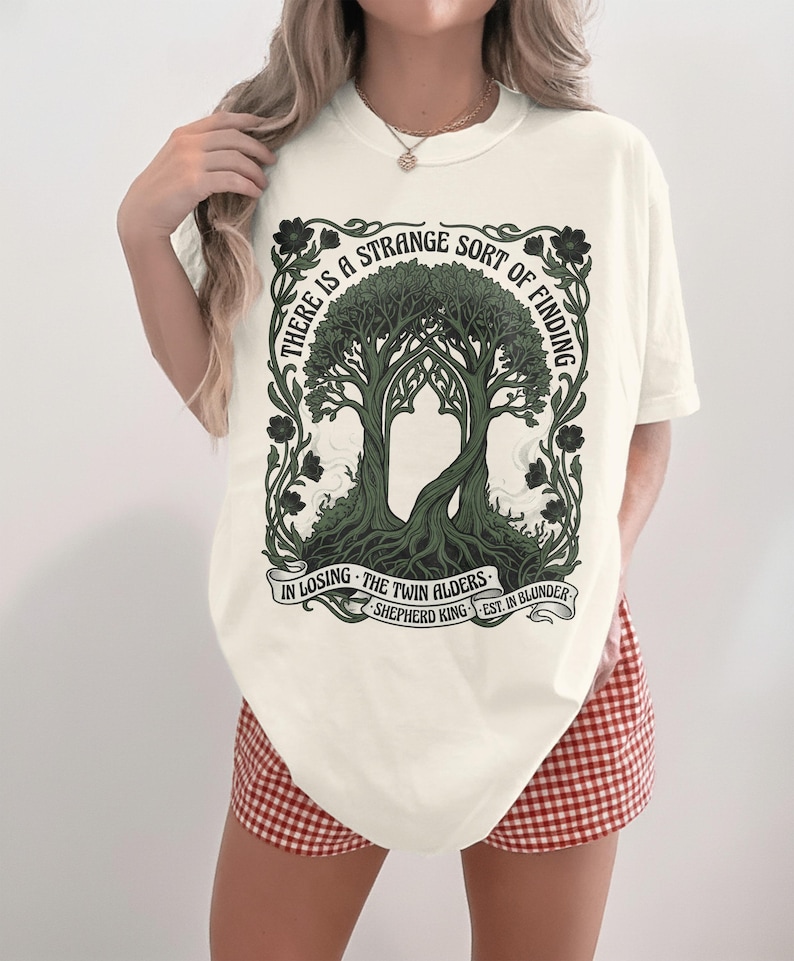 Cream t-shirt with an illustration of two intertwined trees and text.