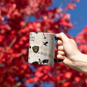 a person holding a coffee mug in front of a tree