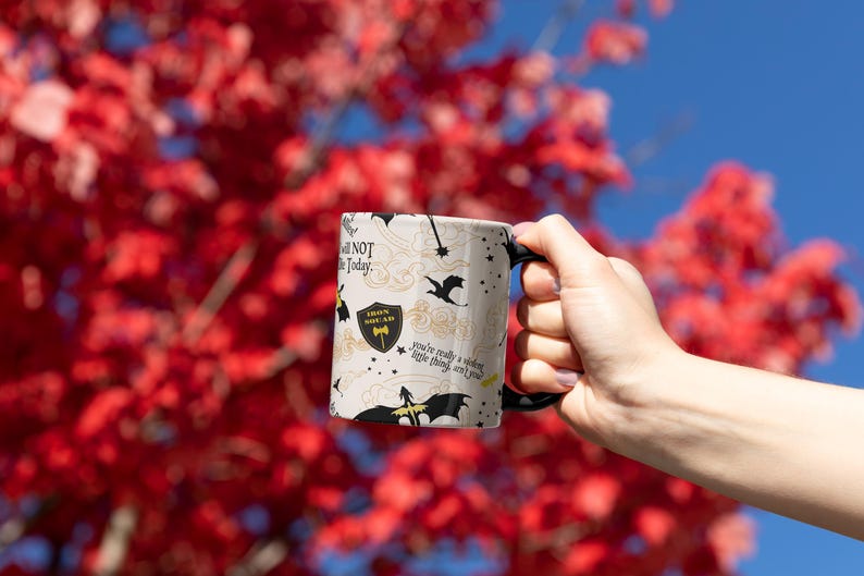 a person holding a coffee mug in front of a tree