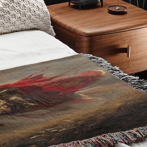 a bed with a painting on it next to a night stand