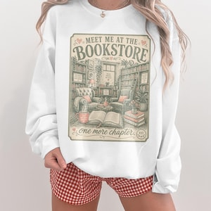 White sweatshirt with "Meet Me At The Bookstore" and book-themed illustrations.