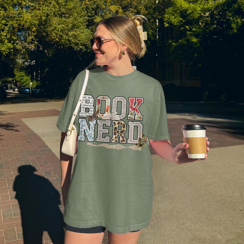 T-shirt with "BOOK NERD" text in floral and vintage letter patterns.