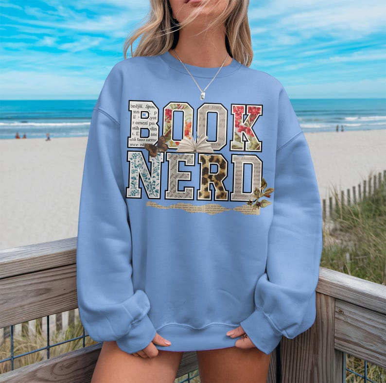 Light blue sweatshirt with "BOOK NERD" text made of book pages and textures.