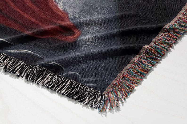 a close-up view of a black and red fabric with a fringed edge, showcasing its texture and pattern.