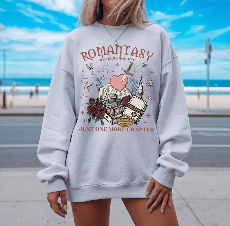 a woman wearing a sweatshirt with a book and heart on it