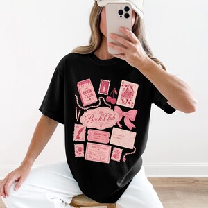 Black t-shirt with pink "Book Club" graphics and postage stamps.