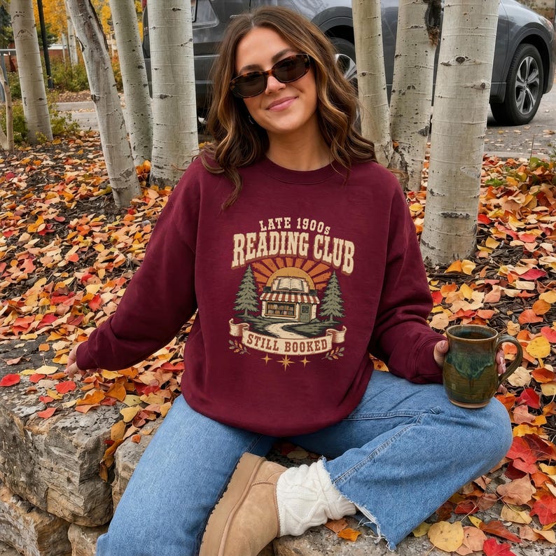 Maroon sweatshirt with "Late 1900s Reading Club Still Booked" graphic.