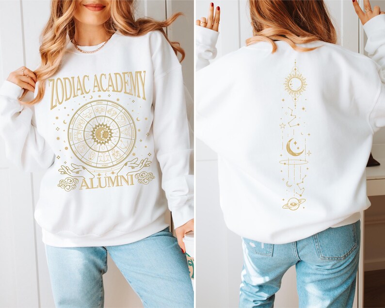 a woman wearing a white sweatshirt with gold lettering