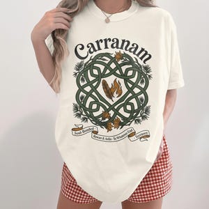 Cream t-shirt with a Celtic knot design featuring "Carranam" in leafy script.