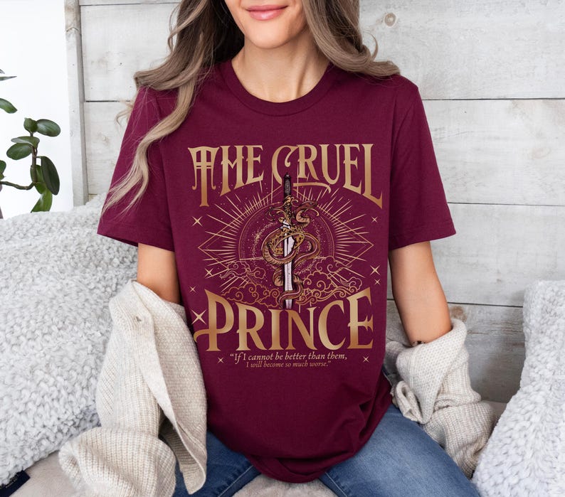 a woman sitting on a bed wearing a t - shirt that says the cruel prince