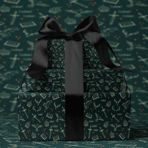 A gift box with a black ribbon tied around it, featuring a repeating pattern of various objects such as books, crowns, and a dragon.